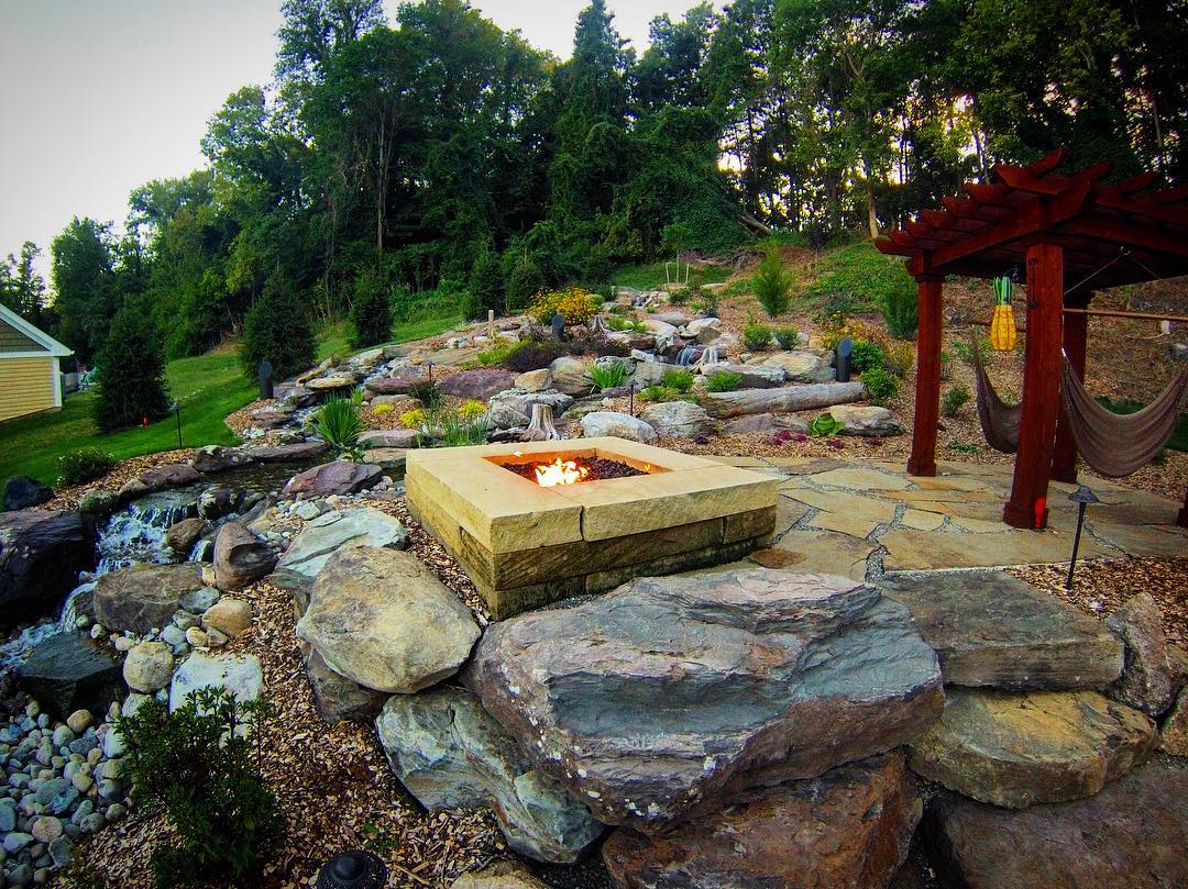 Natural stone patio with gas fire pit and pergola